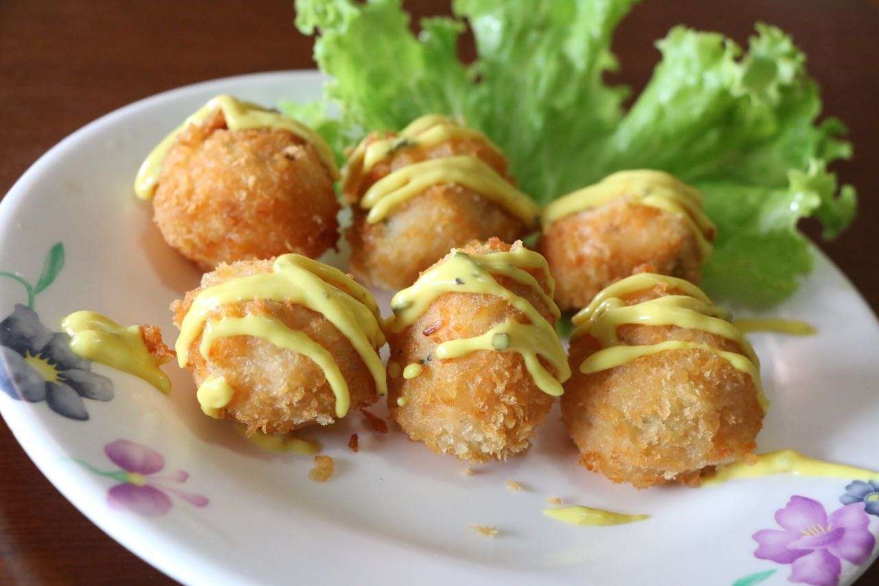 Bolinhos de salmão fritos com maionese, sobre folha de alface